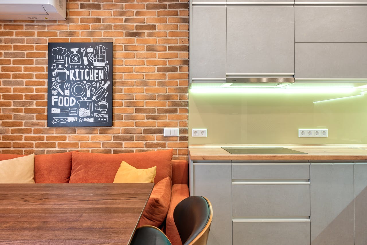 Elegant kitchen area with modern cabinetry and brick wall decor, showcasing cozy design.